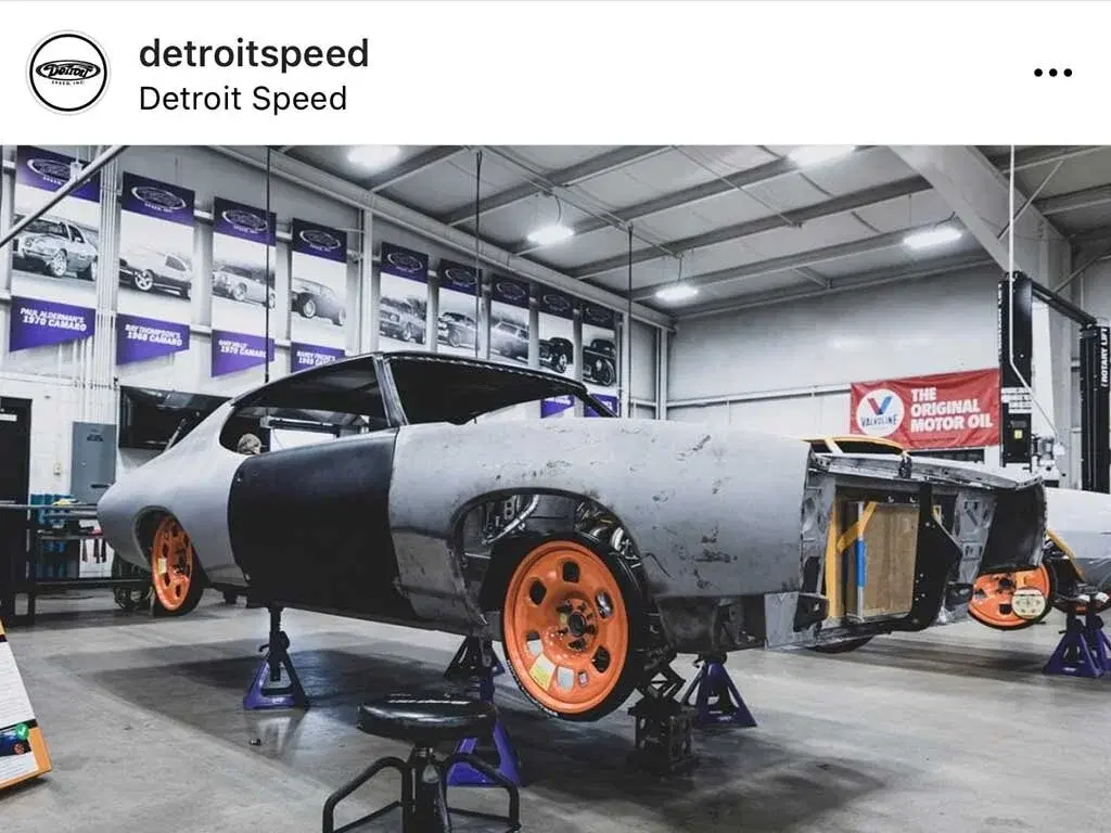 Detroit Speed workshop with car on orange GuniWheel temporary wheels